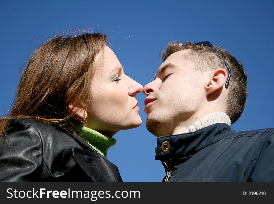 The young man and the girl wish to kiss on a background of the dark blue sky. The young man and the girl wish to kiss on a background of the dark blue sky.