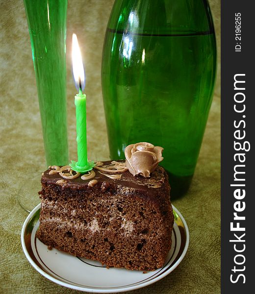 Celebratory table (Chocolate cake with candle and green bottle)