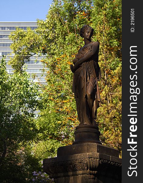 Statue of a woman in the Alameda City Park with trees and modern buildings in the back, Down town Mexico City, Mexico, Latin America