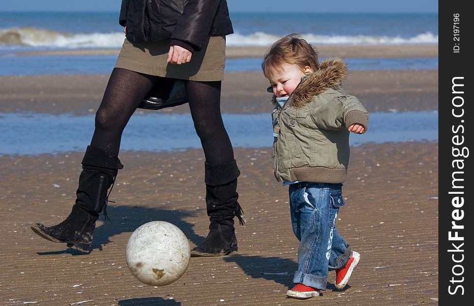 Young boy playing soccer on the beach