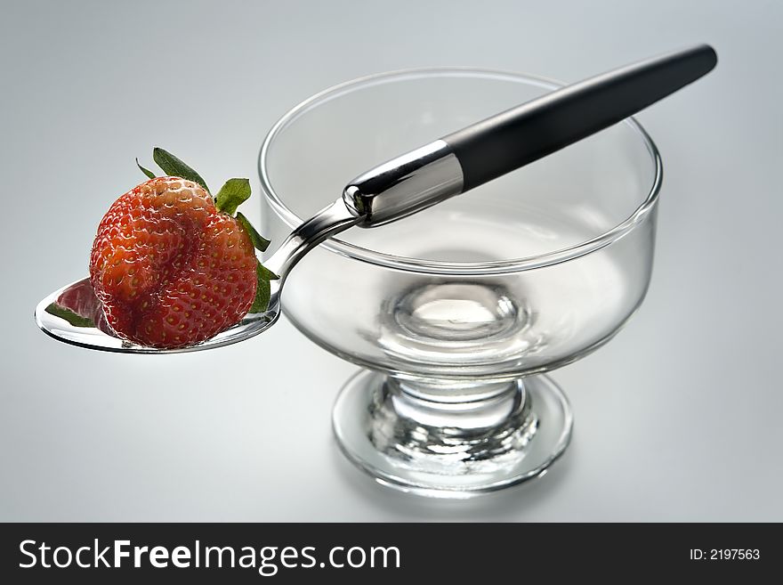 Delightful strawberry in strict laying on the spoon and a glass