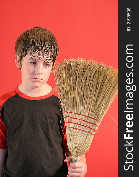 Shot of a mad boy with broom vertical