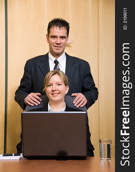 Man and woman in a business room with a laptop. Man and woman in a business room with a laptop