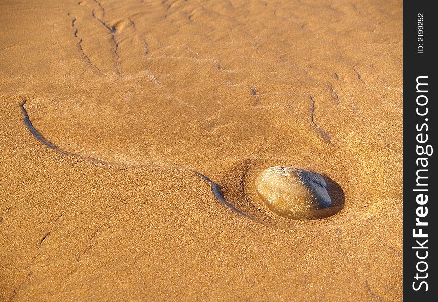 Stone on sandy beach