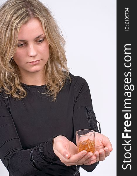 The girl looks at a candle in a hand on a grey background. The girl looks at a candle in a hand on a grey background