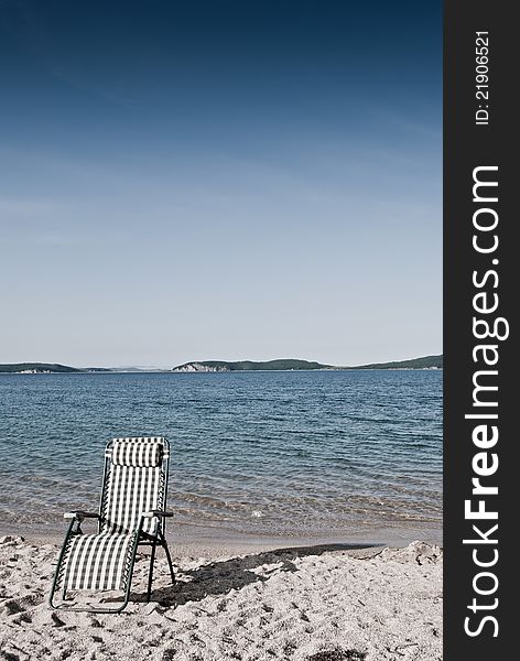 Beach seat on a shore with sand and blue sky