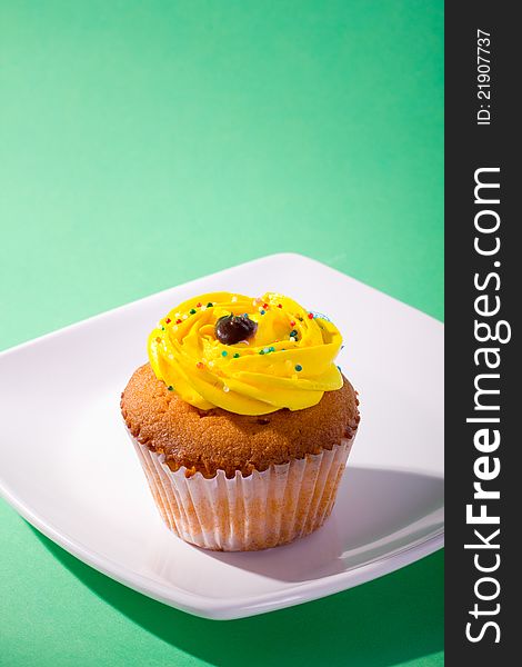 Delicious cupcake on green background.