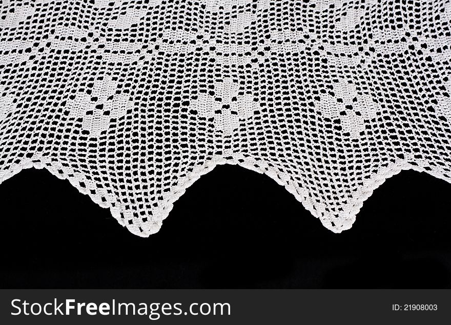 White lace forms a delicate border against black background. White lace forms a delicate border against black background.