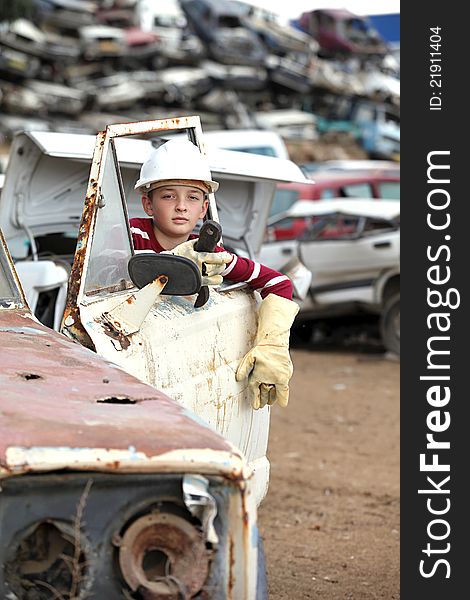 The boy mechanic in a helmet with a key repair. The boy mechanic in a helmet with a key repair