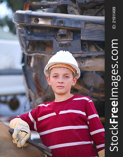 The boy mechanic in a helmet with a key repair
