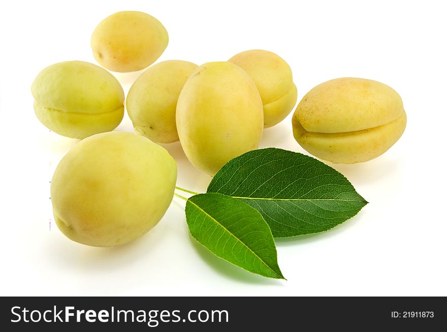 Apricots with green leaves on white