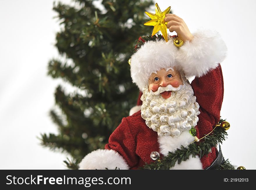 Santa with star ans decorations in front of pine tree