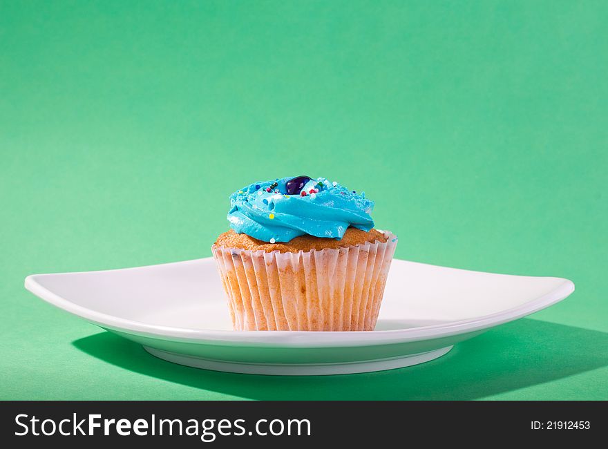 Delicious cupcake on green background.