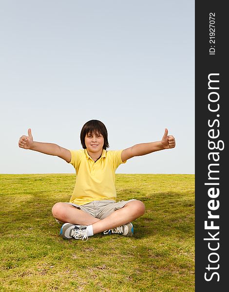 Boy sitting on the grass,and enjoying nature