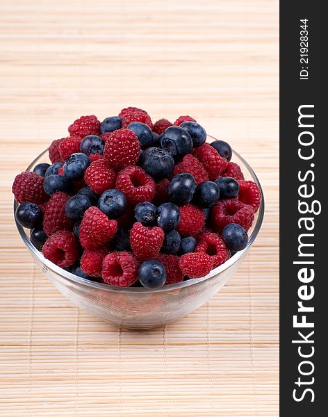 A bowl of fresh raspberries and blueberries. A bowl of fresh raspberries and blueberries