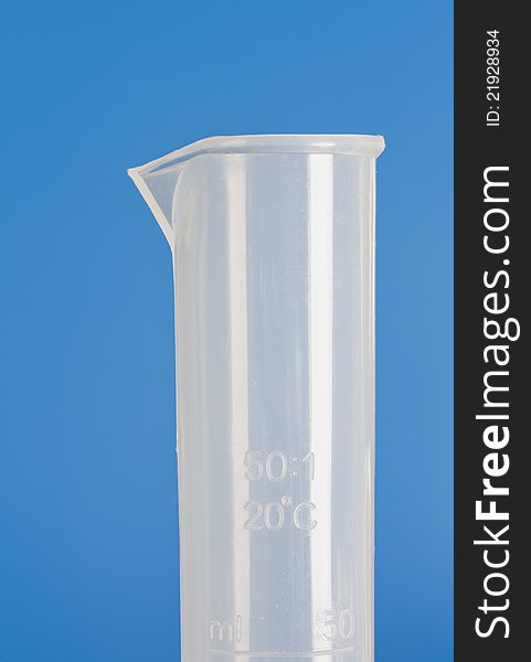 Plastic measuring cylinder on blue background