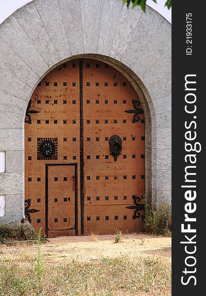 Church doorway with wooden doors and intricate metal hinges.