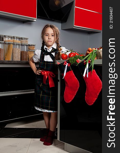 Small beautiful girl, in the form of a cook in the kitchen. Cooking Christmas dinner. Small beautiful girl, in the form of a cook in the kitchen. Cooking Christmas dinner.