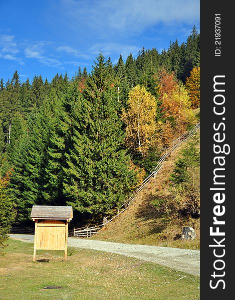 Transylvania mountains in autumn time with curved road and wooden plate near Bran castle of Dracula. Transylvania mountains in autumn time with curved road and wooden plate near Bran castle of Dracula.