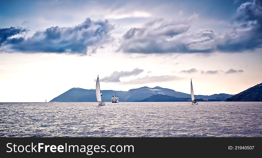 Sailing ship yachts with white sails at the open sea