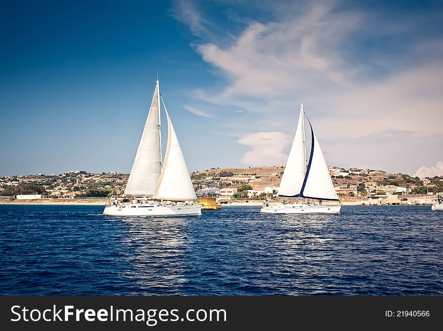 Sailing ship yachts with white sails at the open sea