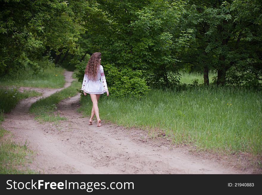 Portrait of a slender young woman with long hair dressed in beautiful national, walks on forest. Portrait of a slender young woman with long hair dressed in beautiful national, walks on forest