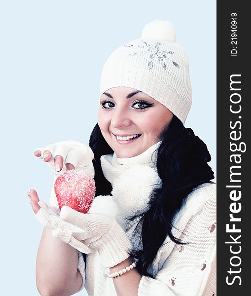 Girl is in winter clothes holds an apple. Girl is in winter clothes holds an apple