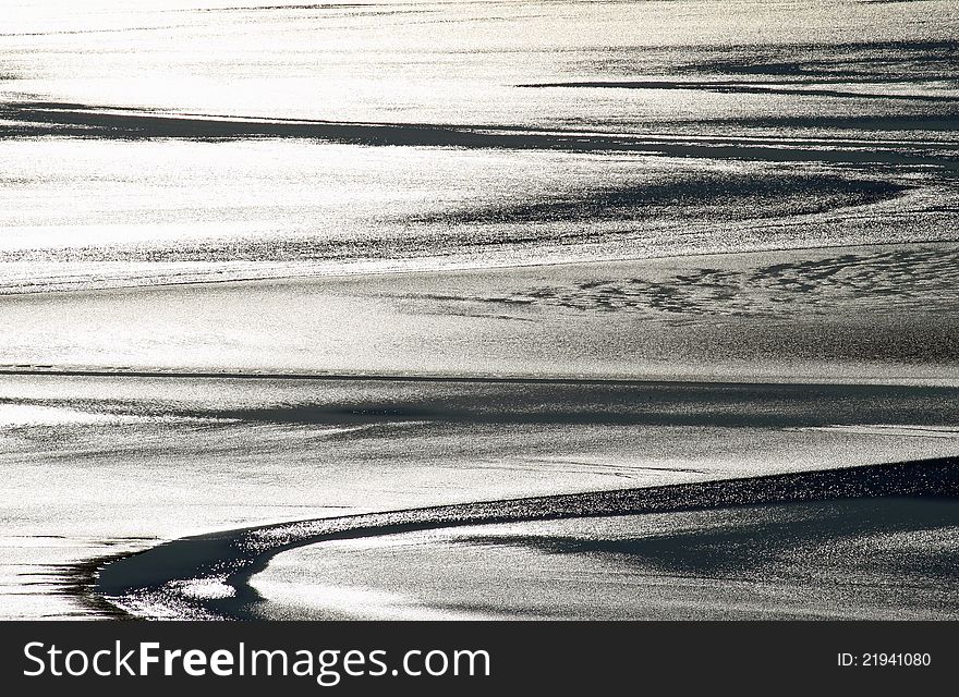 Sunlight Reflecting Off Wet Sand And Water