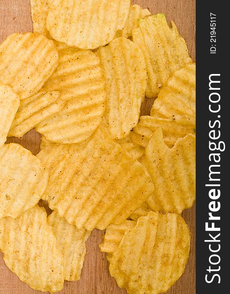 Rippled potato chips over wooden background