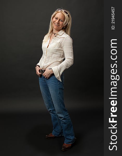 Studio shot of a blonde cowgirl leaning back with a big smile. Studio shot of a blonde cowgirl leaning back with a big smile