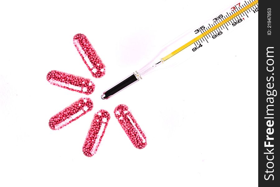 Macro shot of medical thermometer and tablets isolated on the white background