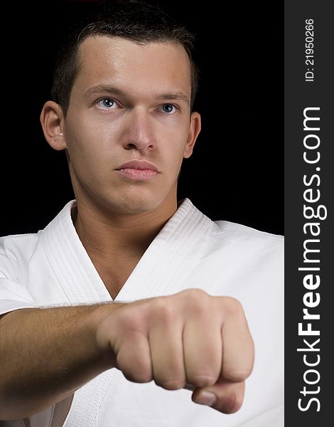 High Contrast karate young male fighter on black background. High Contrast karate young male fighter on black background.