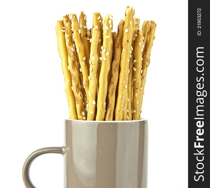 Crispy bread sticks put in mug isolated on white