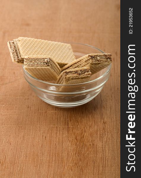 Chocolate wafer in the glass bowl. Shot on wooden background