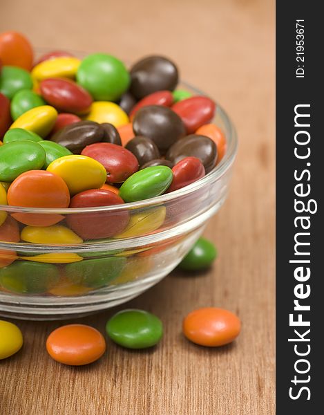 Chocolate candy in glass bowl shot on wooden background