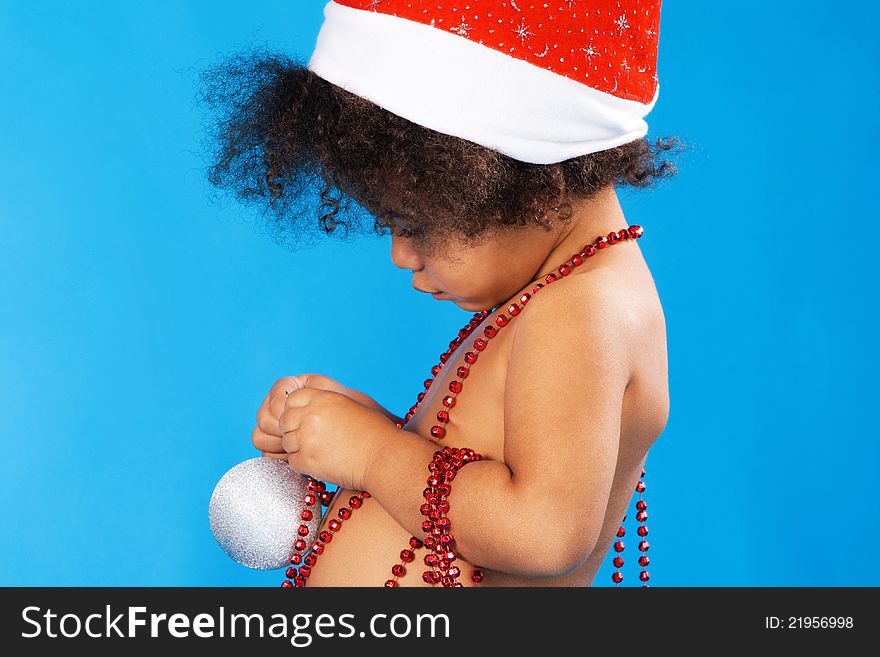 Little child in Christmas hat playing with toys. Little child in Christmas hat playing with toys