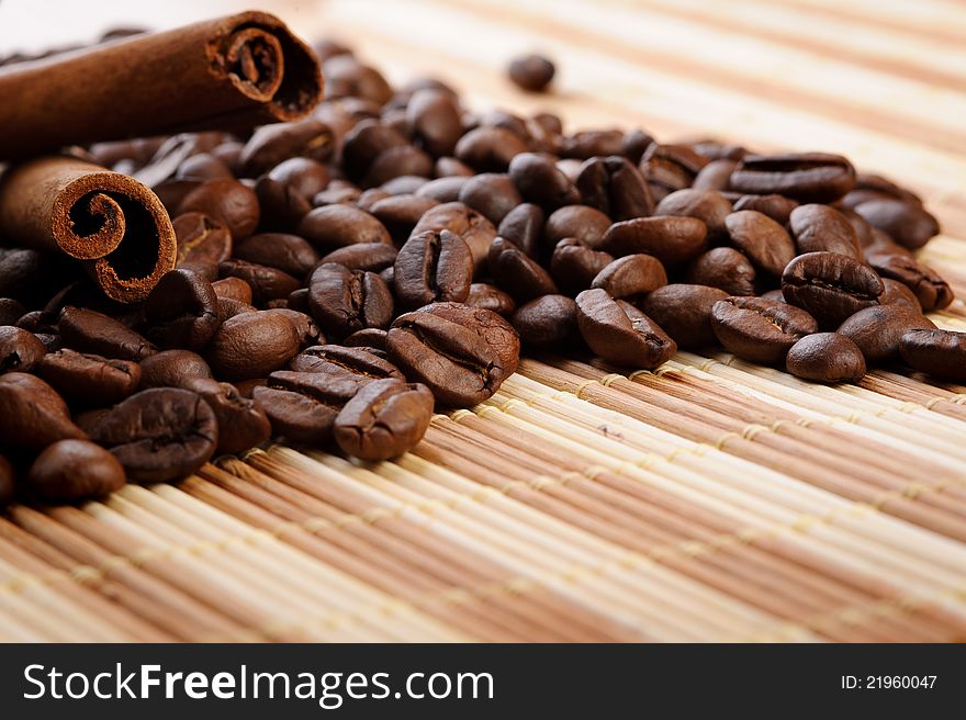 Handful aromatic coffee beans with cinnamon
