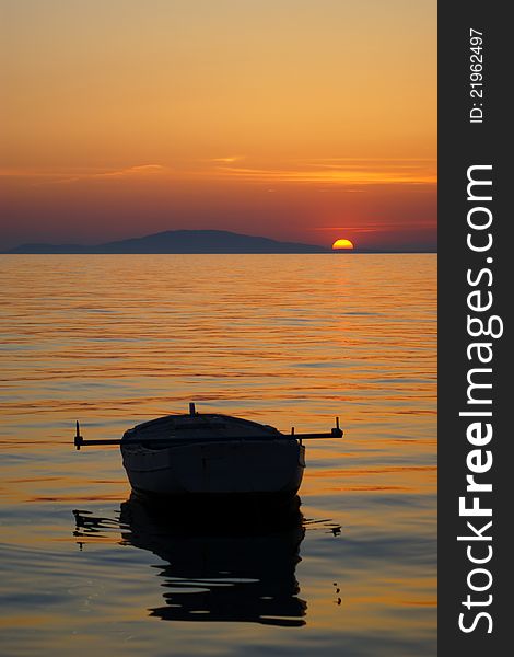 Sunset with fishing boat on the coast of Adriatic sea on island of Pag