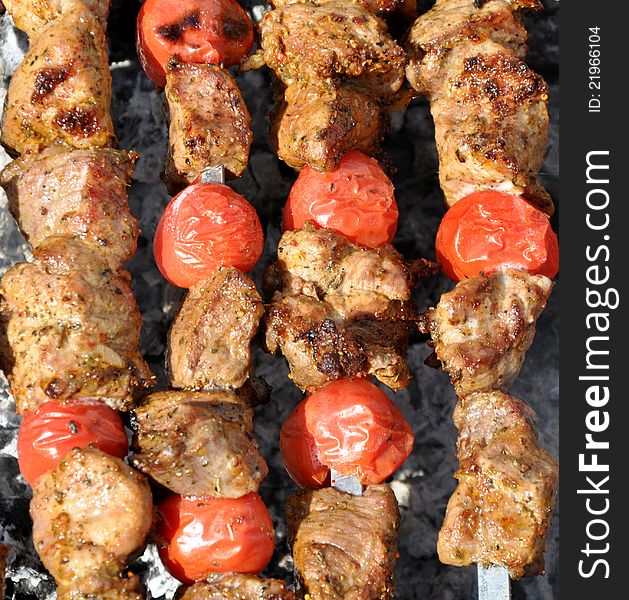 Pork shashlik with tomatoes preparation on fire. Pork shashlik with tomatoes preparation on fire