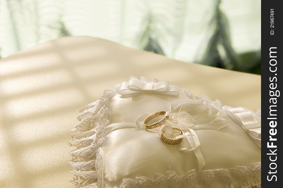 Gold wedding rings on a  pillow