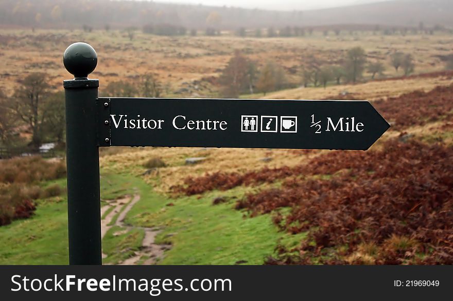 A sign displaying visitor centre half mile. A sign displaying visitor centre half mile