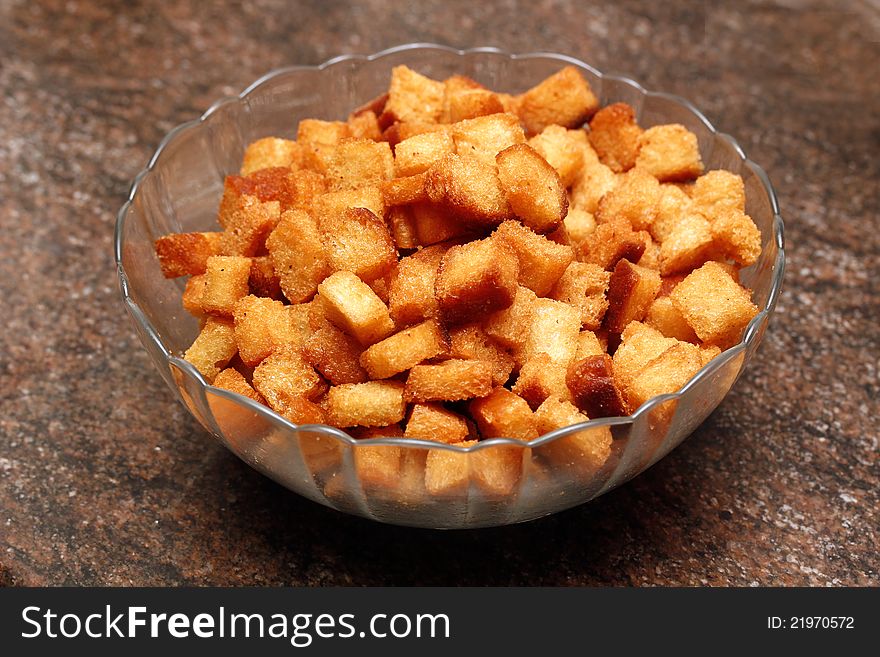 Fried bread pieces in golden brown color arranged in a glass bowl