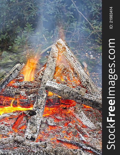 Burning timber bonfire with smoke