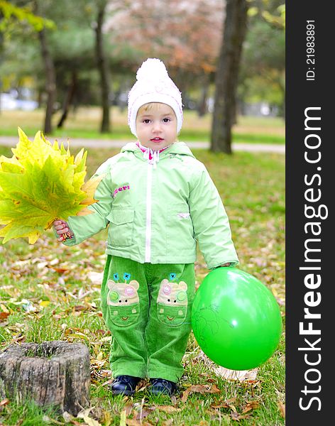 Small beautiful girl in green suit on green glade