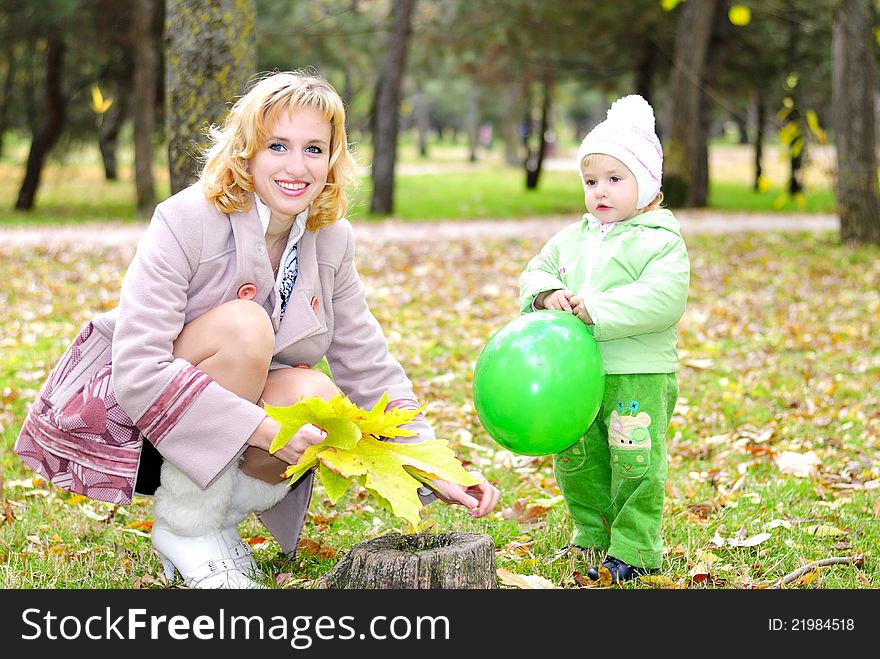 Small beautiful girl in green suit with mother