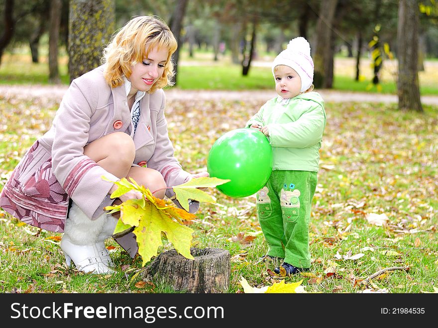 Small beautiful girl in green suit with mother