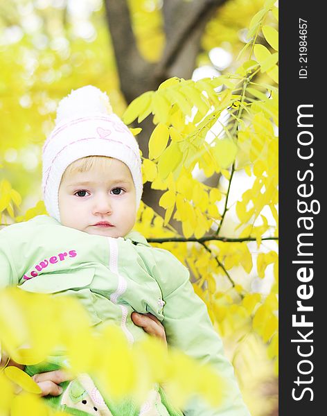 Small beautiful girl in green suit on green glade