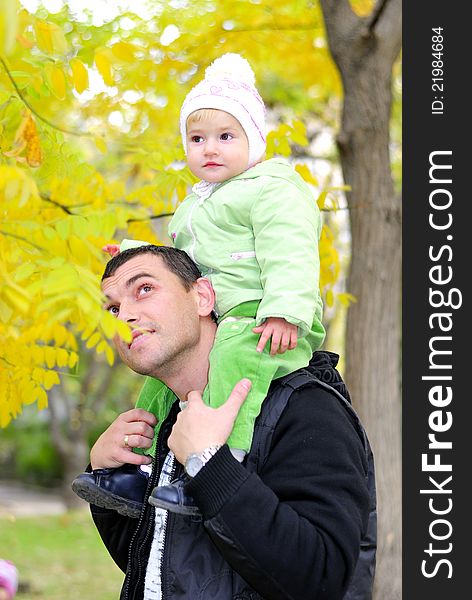 Small beautiful girl in green suit with father