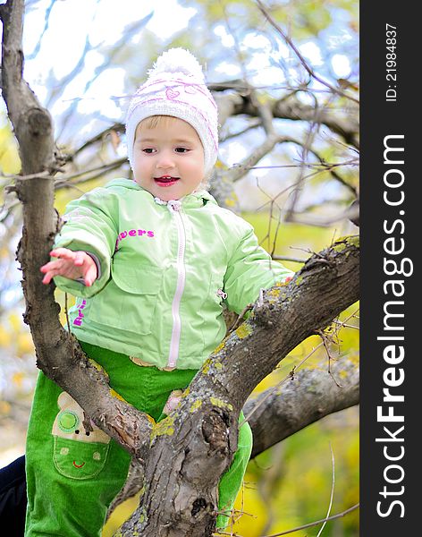 Small girl on tree by autumn