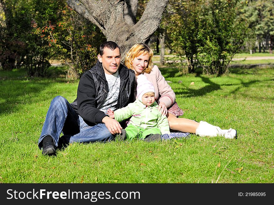 Small beautiful girl with parent on green glade